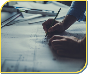 person writing on blue print plans